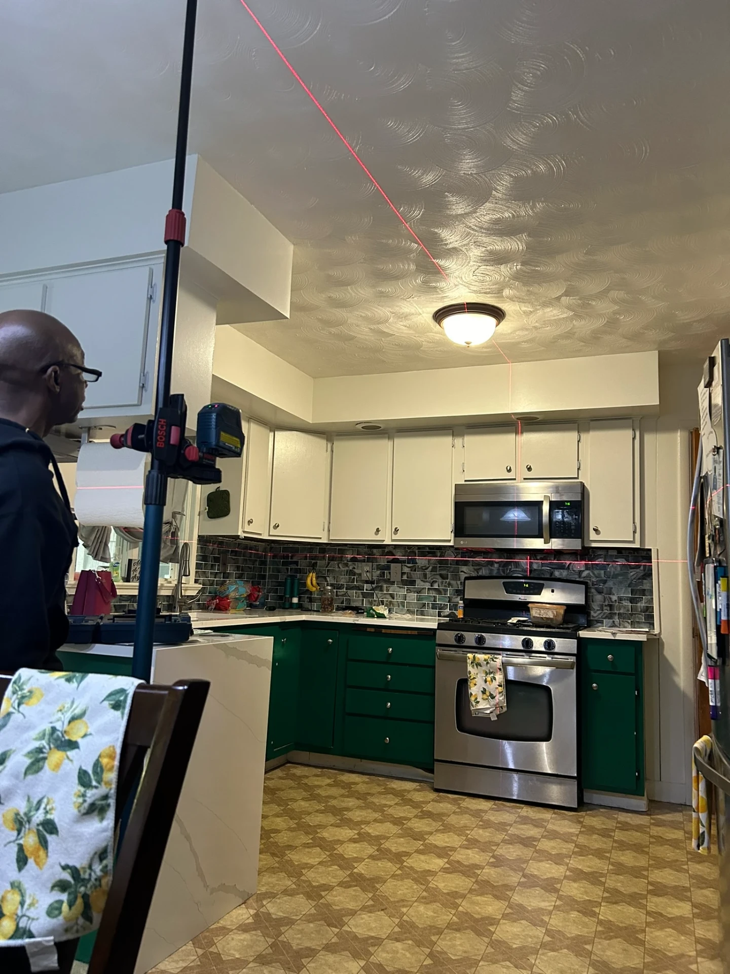 Ken Beaty using laser level for precision kitchen work